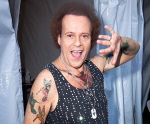 Richard Simmons is seen at the 2013 LA Gay Pride Festival. After Simmons' death this past July, he was laid to rest wearing his iconic workout attire, according to his brother.