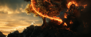 An elven warrior and a balrog battle on a mountaintop near a tree in The Lord of the Rings: The Rings of Power