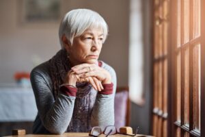 older woman staring and thinking out of window