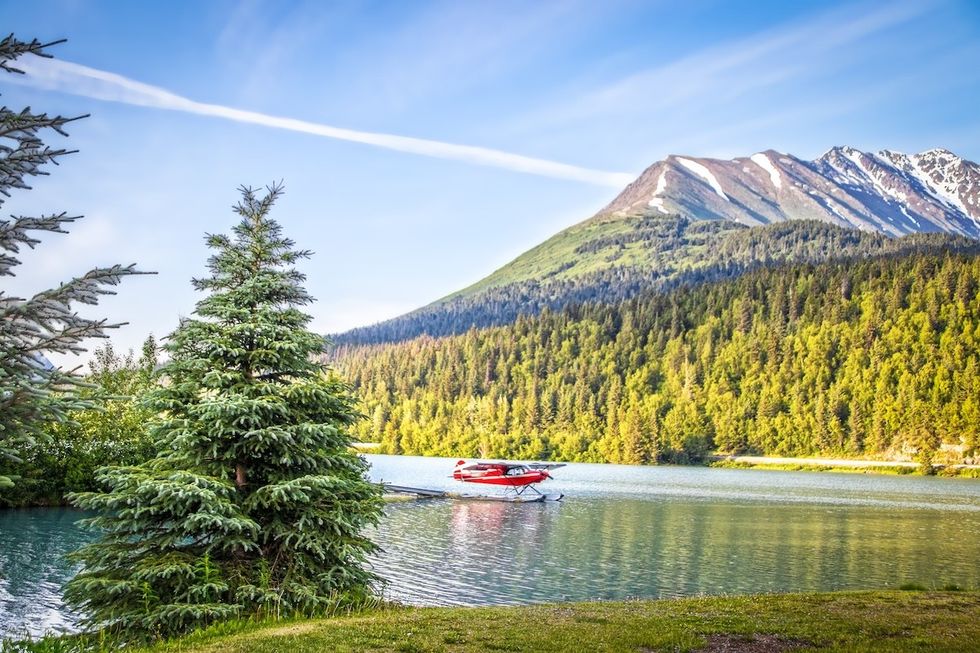 red sea plane landing in Upper Trail Lake on the Kenai Peninsula of Alaska