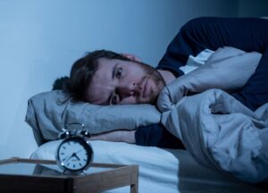 Sleepless man awake at night not able to sleep, feeling frustrated