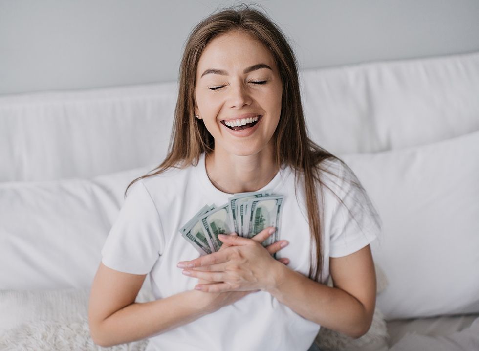 A happy woman holding a handful of cash