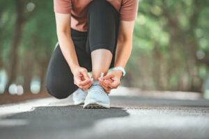 woman tying shoe before going for a walk