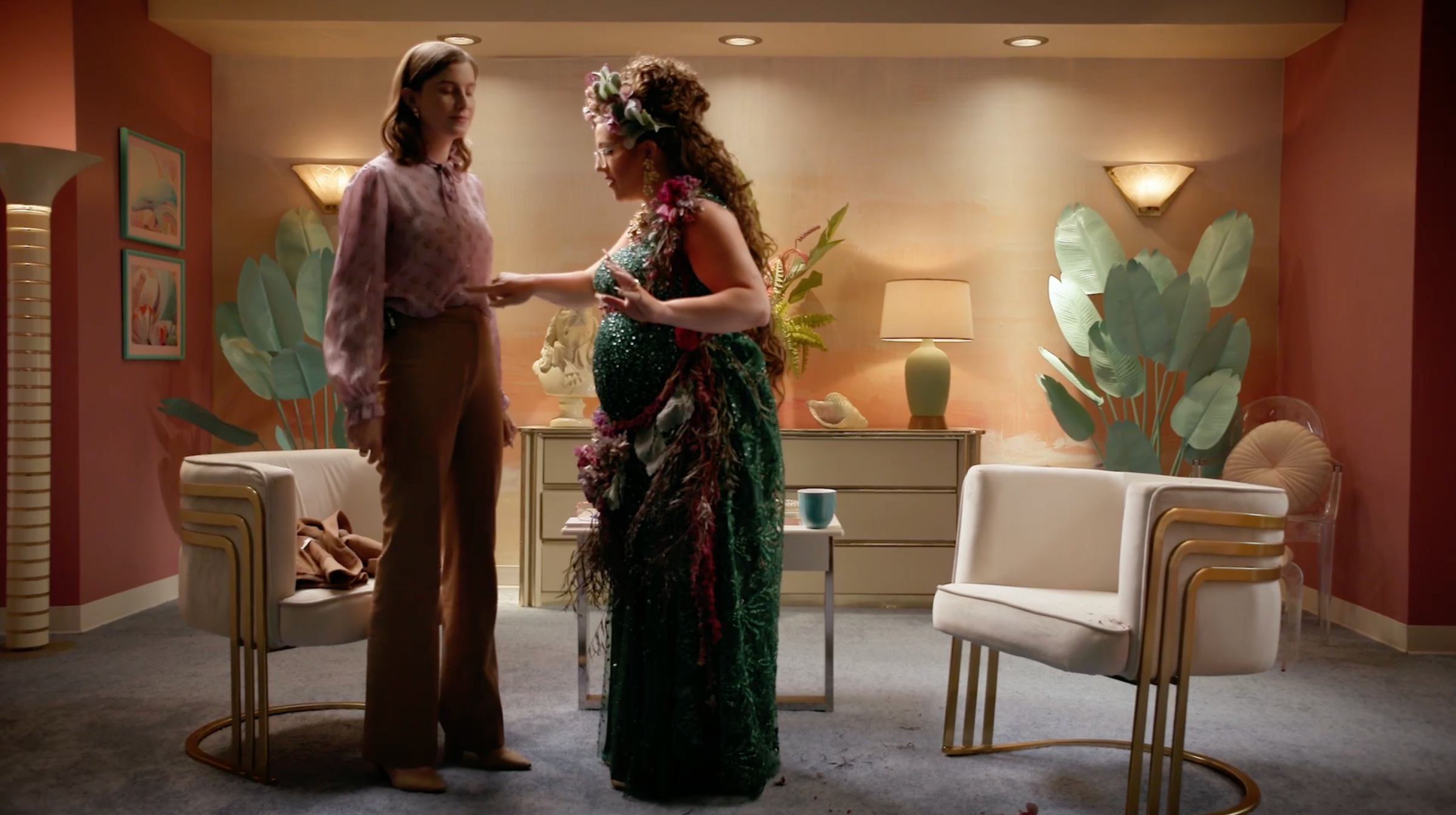 Vic Michaelis and Izzy Roland as Vic Michaelis and Leighanna-Jean Gruthers in Very Important People. Leighanna-Jean, dressed in an elaborate dress and headress, is poking Vic in the stomach as Vic looks tired.