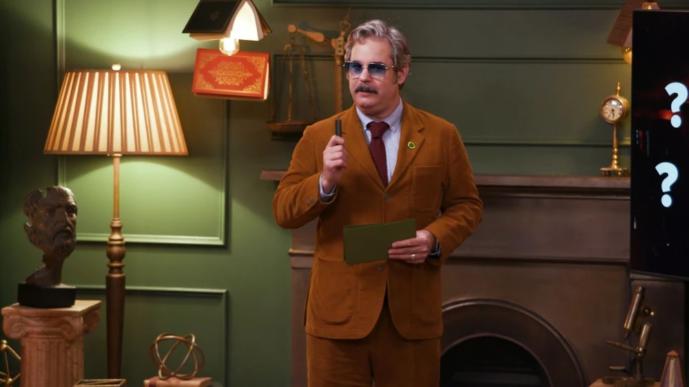 Paul F. Tompkins, giving his presentation in Smartypants, holds a pen up with index cards in his hands