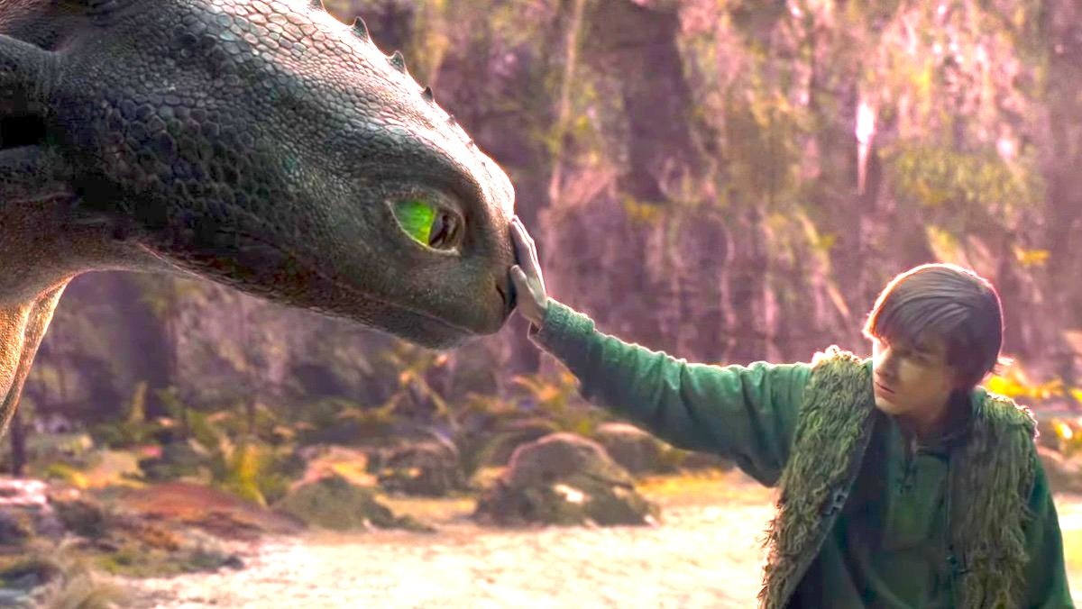 A young boy touches the snout of Toothless the Dragon in the live-action How to Train Your Dragon