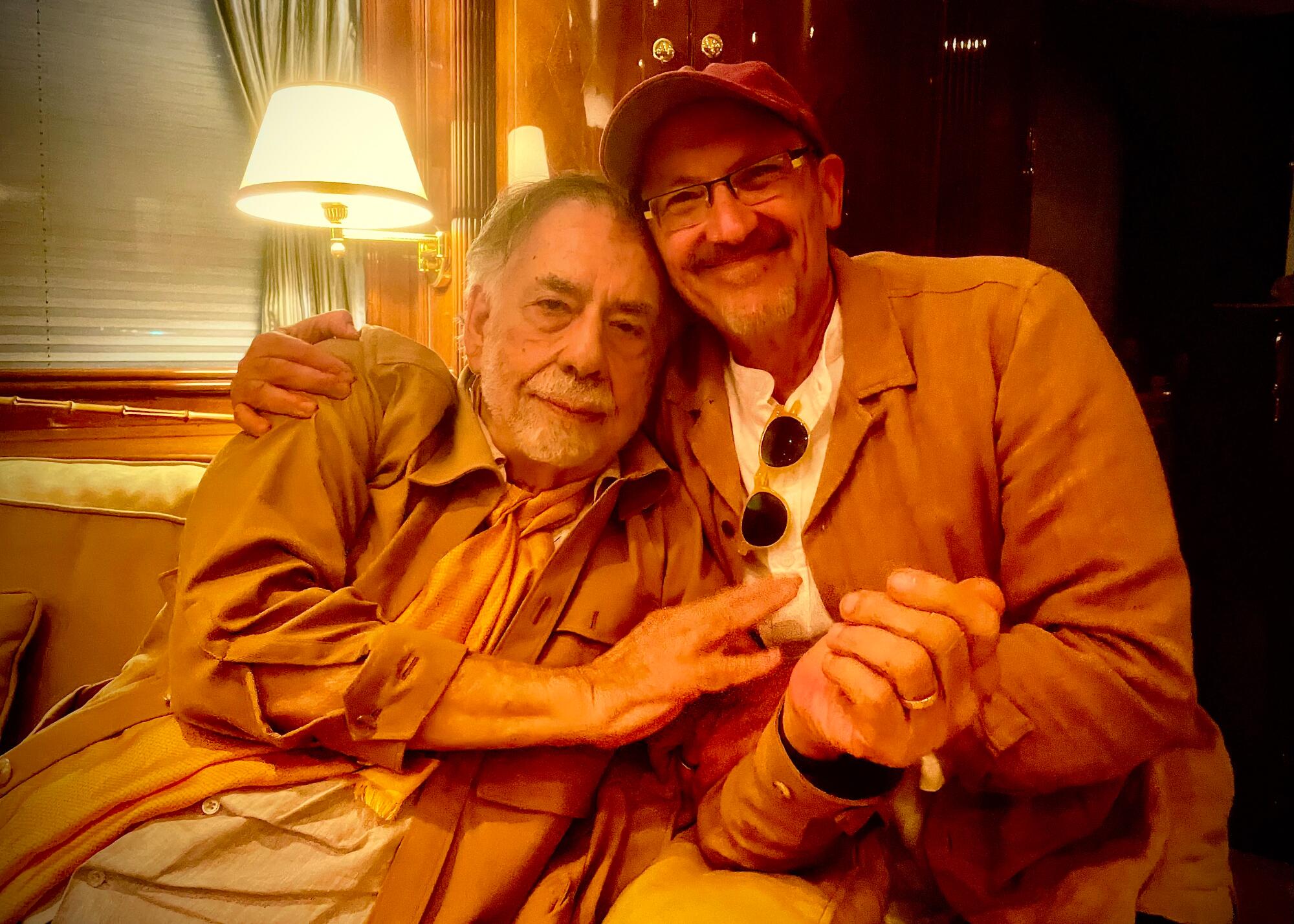 Francis Ford Coppola and Osvaldo Golijov lean in together over the arm of a couch for a portrait.