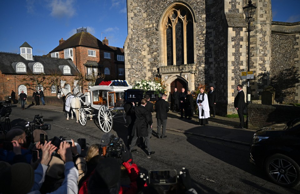 Pallbearers carry the coffin of the late singer