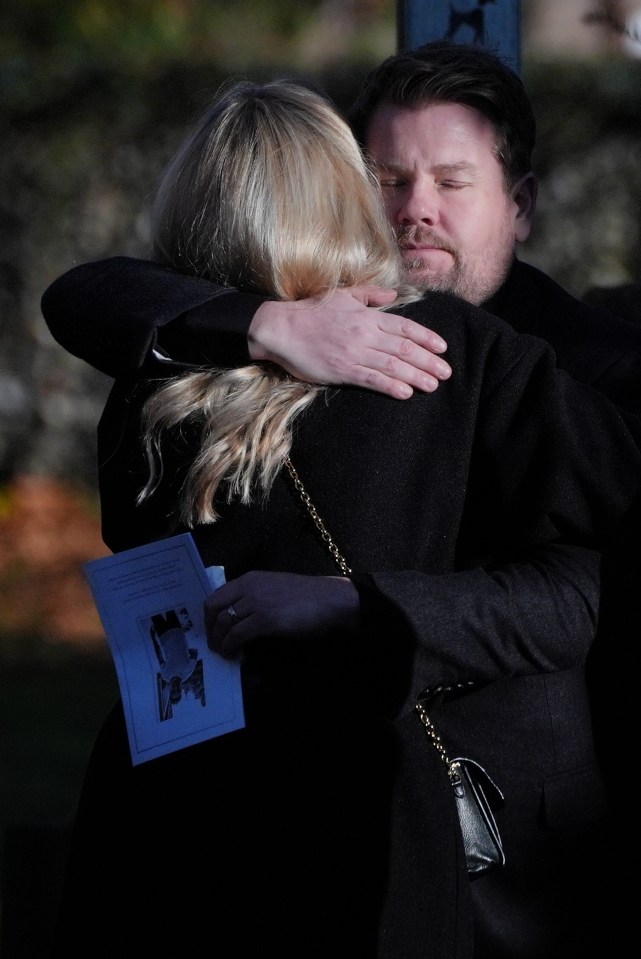 James Corden embraces a mourner at the service