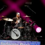 Anderson .Paak seated behind a drum kit