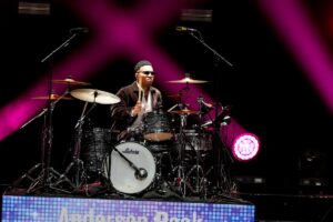 Anderson .Paak seated behind a drum kit