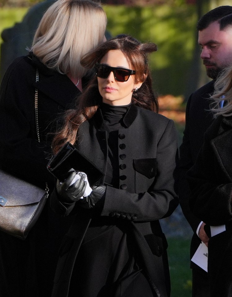 Cheryl looked sombre as she left the church