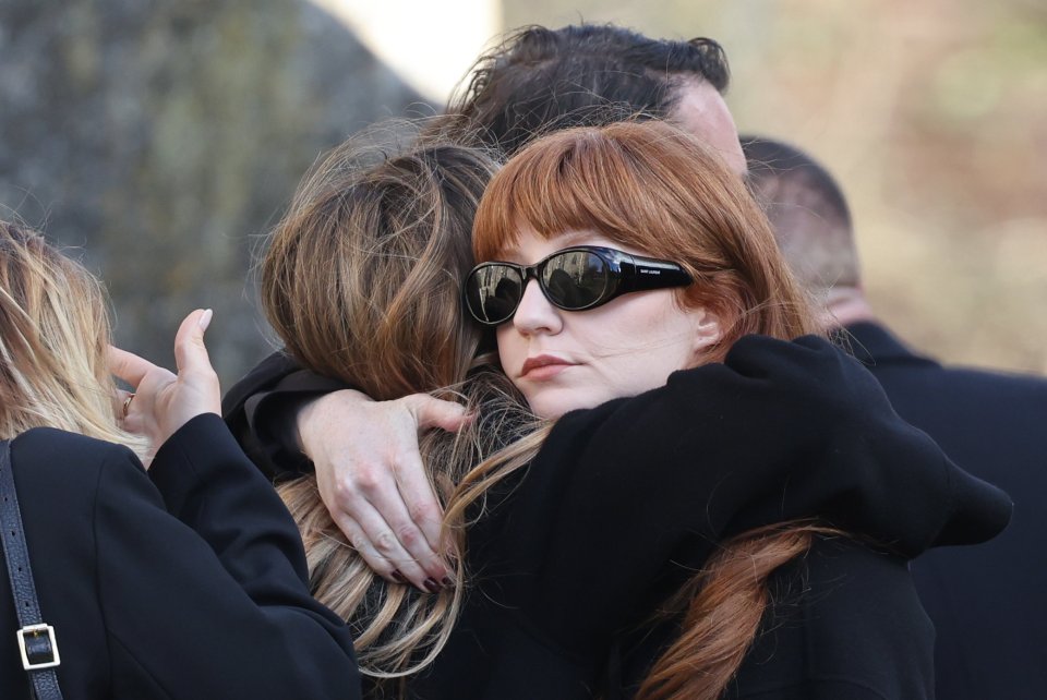 Nicola Roberts hugged other mourners as they joined a crowd gathering outside