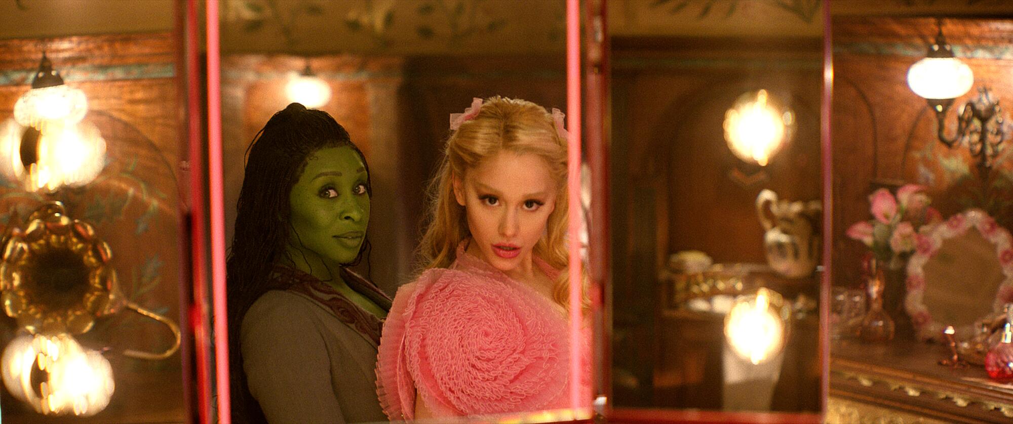 Cynthia Erivo and Ariana Grande look into a mirror in "Wicked."