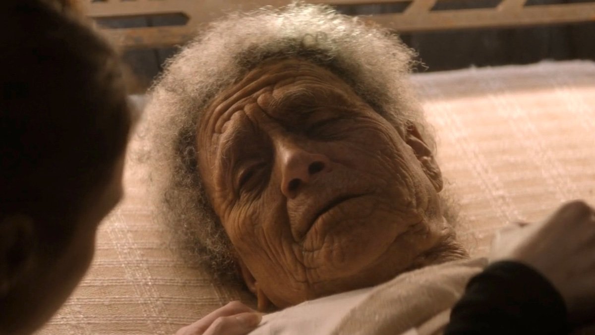 An old woman with white hair lying in bed on Dune: Prophecy