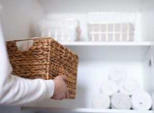 A woman declutters and tidies a cupboard