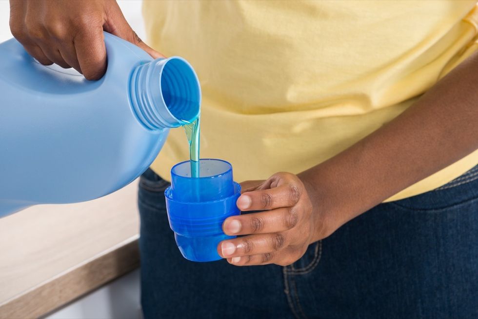 A woman pouring laundry detergent in a cup