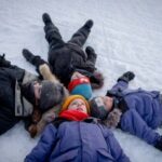 (Clockwise from left) Mia, Colin, Laurent, and Léo Pelletier lay in the snow and look up to the sky in Kuujjuaq, Canada