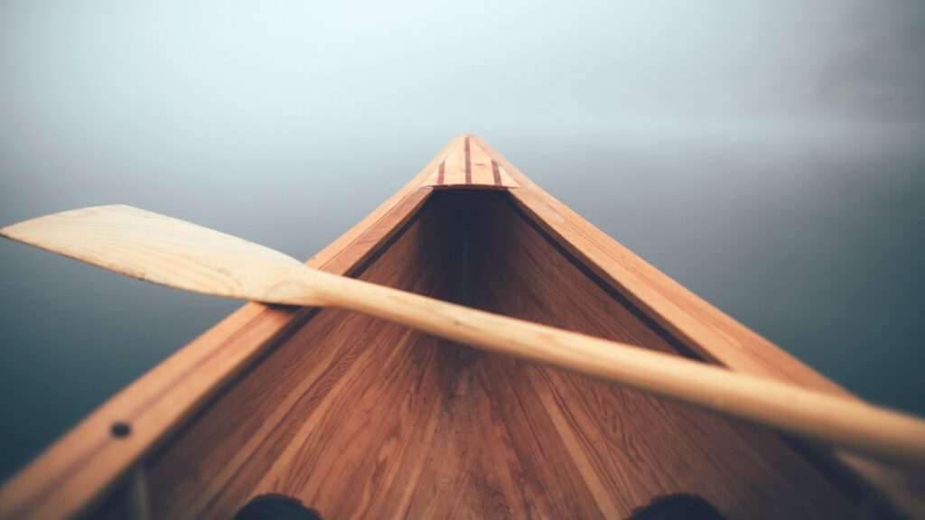 paddling a wooden canoe