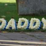 A floral tribute reading 'Daddy' outside the church