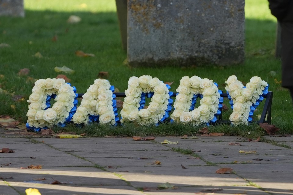 A floral tribute reading 'Daddy' outside the church