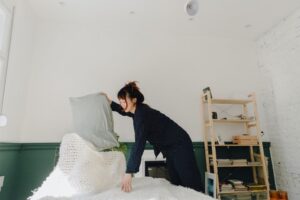 Photo of a young woman making her bed