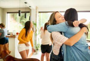 Shot of a woman greeting and welcoming her friend at party