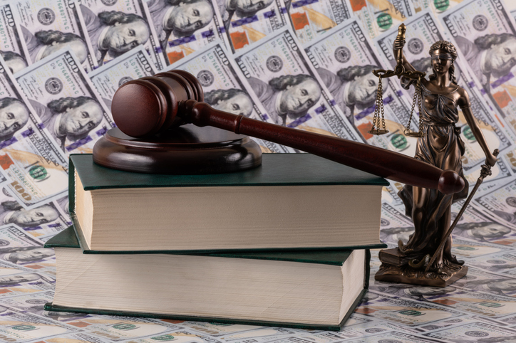 Themis figure and a judge's gavel against the background of $100 bills