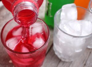 Flavored water being poured into a glass of ice