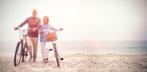 older couple with bikes on the beach