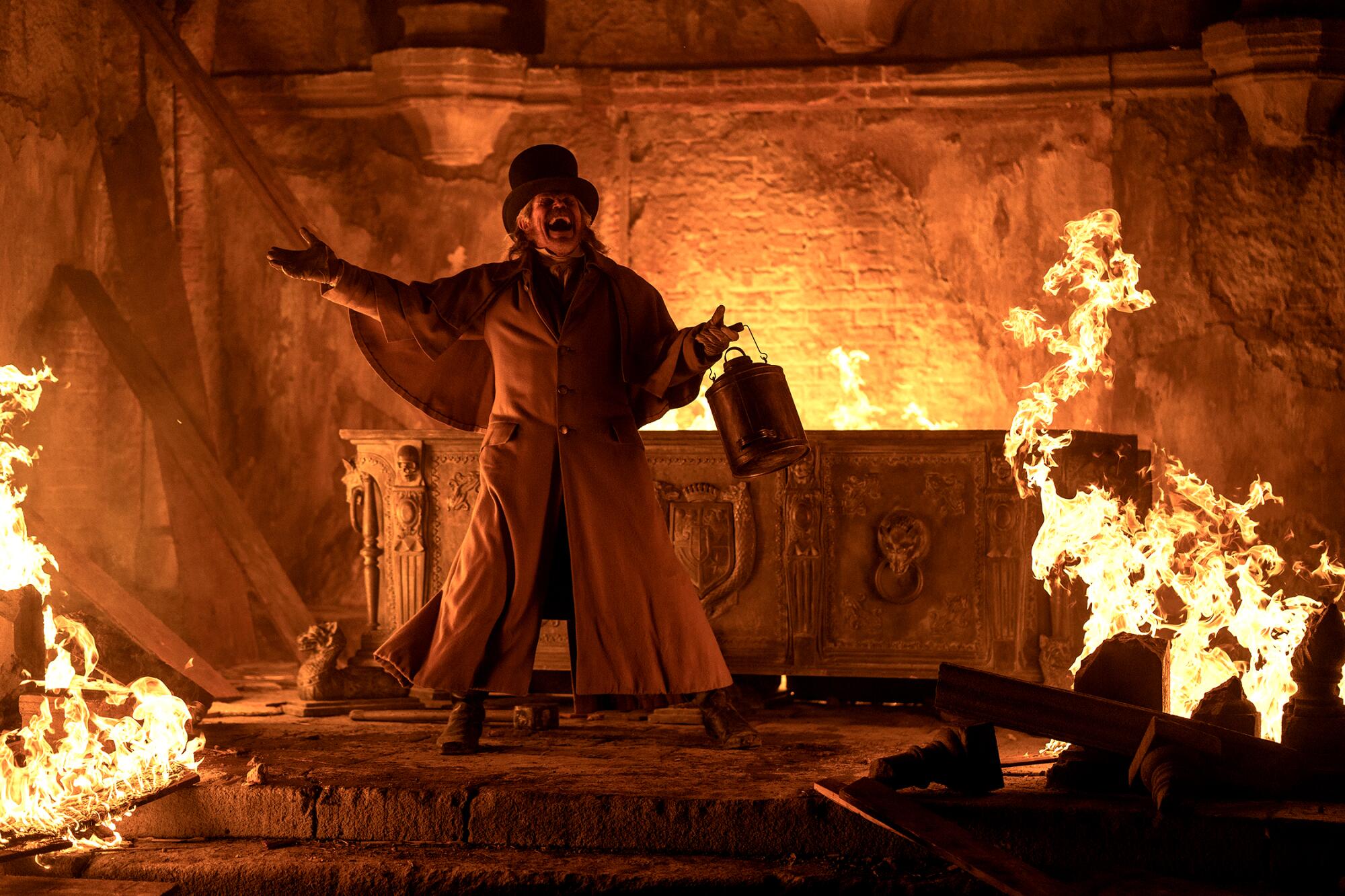 A hysterical man standing by a crypt with flames all around in "Nosferatu."