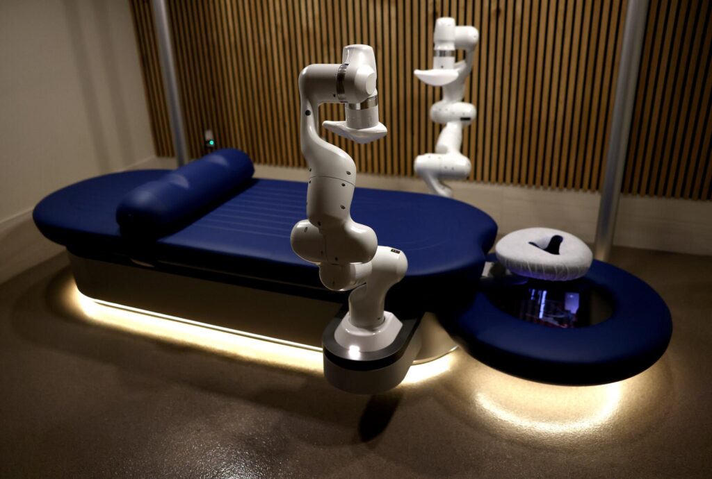 An empty massage table with robotic arms.