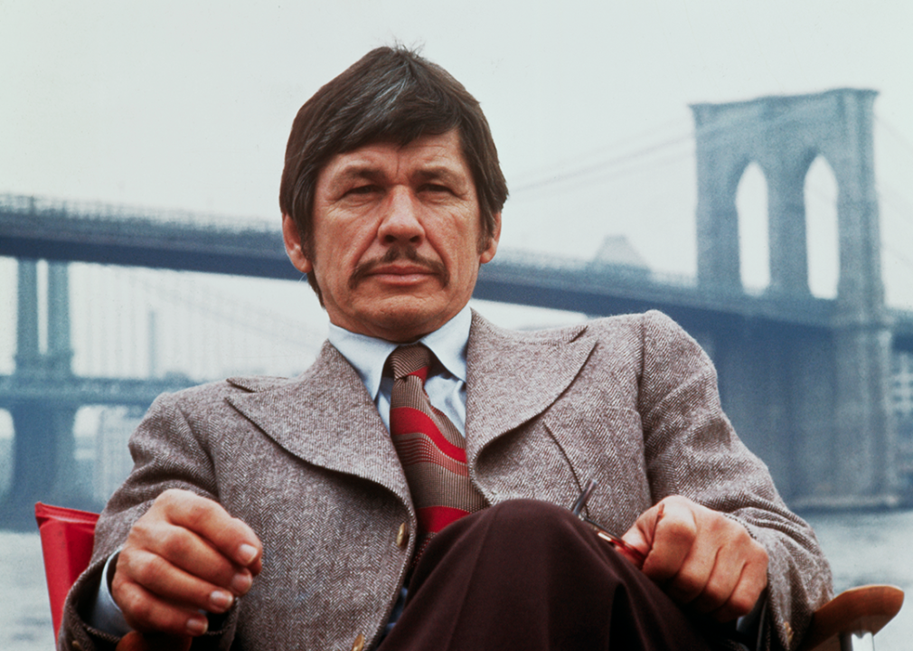 Charles Bronson seated on the banks of the East River.