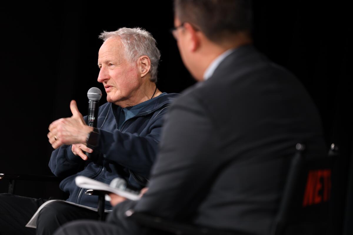 A director speaks at a postscreening Q&A as another man seated next to him looks on.