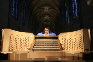 Olivier Latry rests his arms on the refurbished organ at Notre Dame Cathedral.