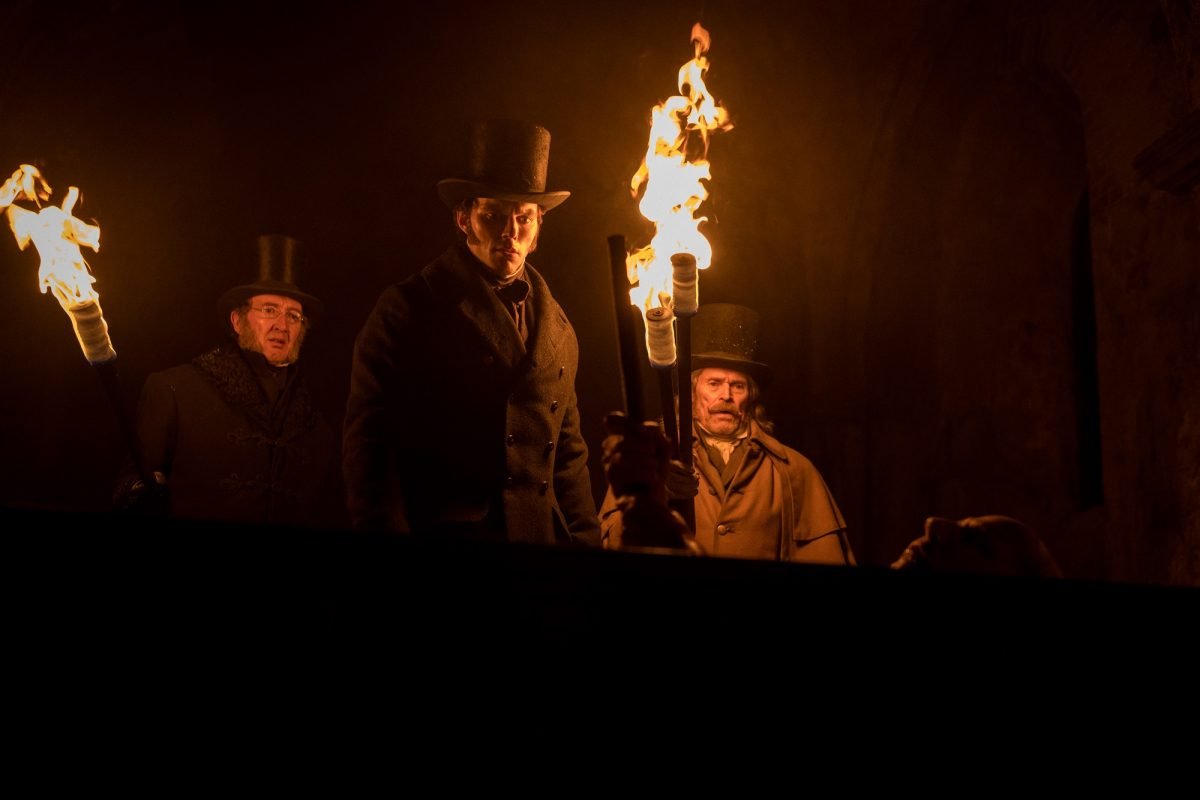 (l-r.) Ralph Ineson stars as Dr. Wilhelm Sievers, Nicholas Hoult as Thomas Hutter and Willem Dafoe as Professor Albin Eberhart von Franz in director Robert Eggers’ NOSFERATU, a Focus Features release.