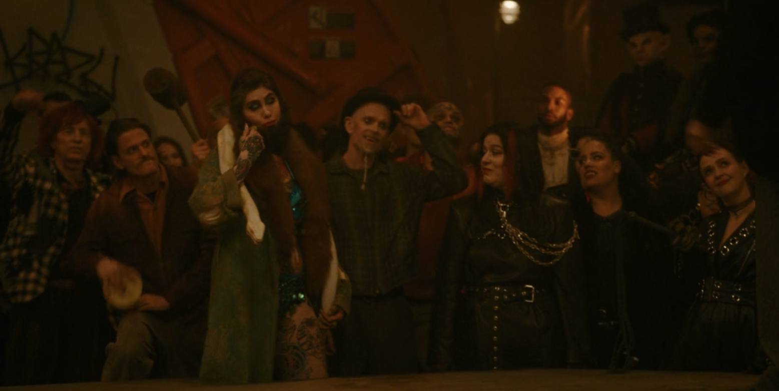 A group of Carnies next to some vampire ladies in leather in What We Do in the Shadows