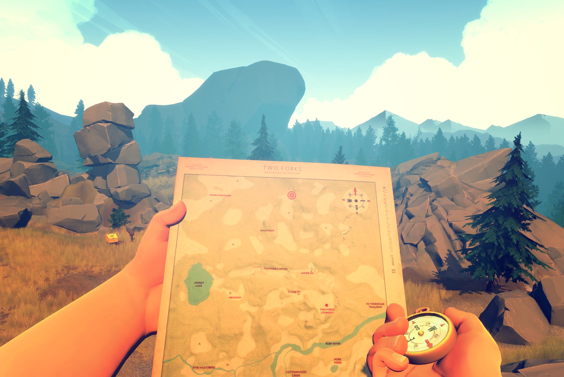 Hands hold a map and compass up in front of a rocky landscape in Firewatch