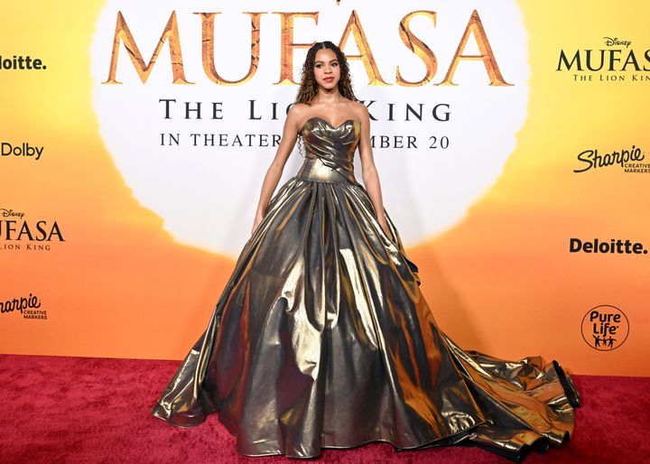 Blue Ivy poses in her gold ballgown at the "Mufasa" event.