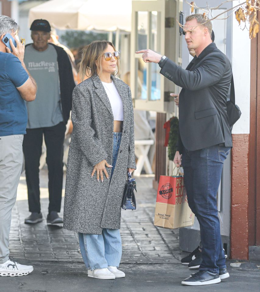 Jen, in a coat and crop top, was seen looking up admiringly at the protection officer while shopping in Los Angeles