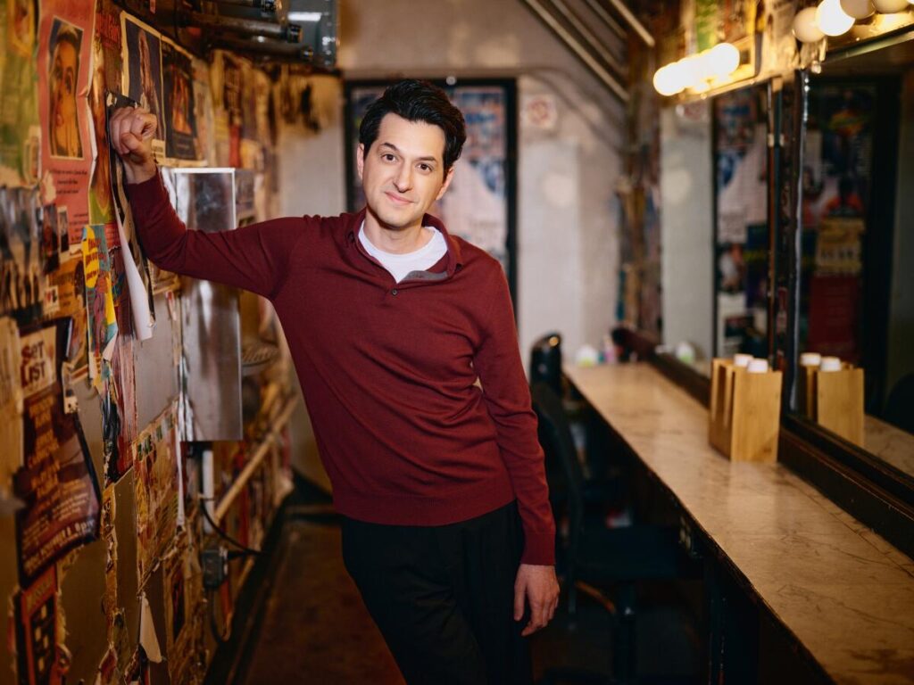 Ben Schwartz leans against a wall.