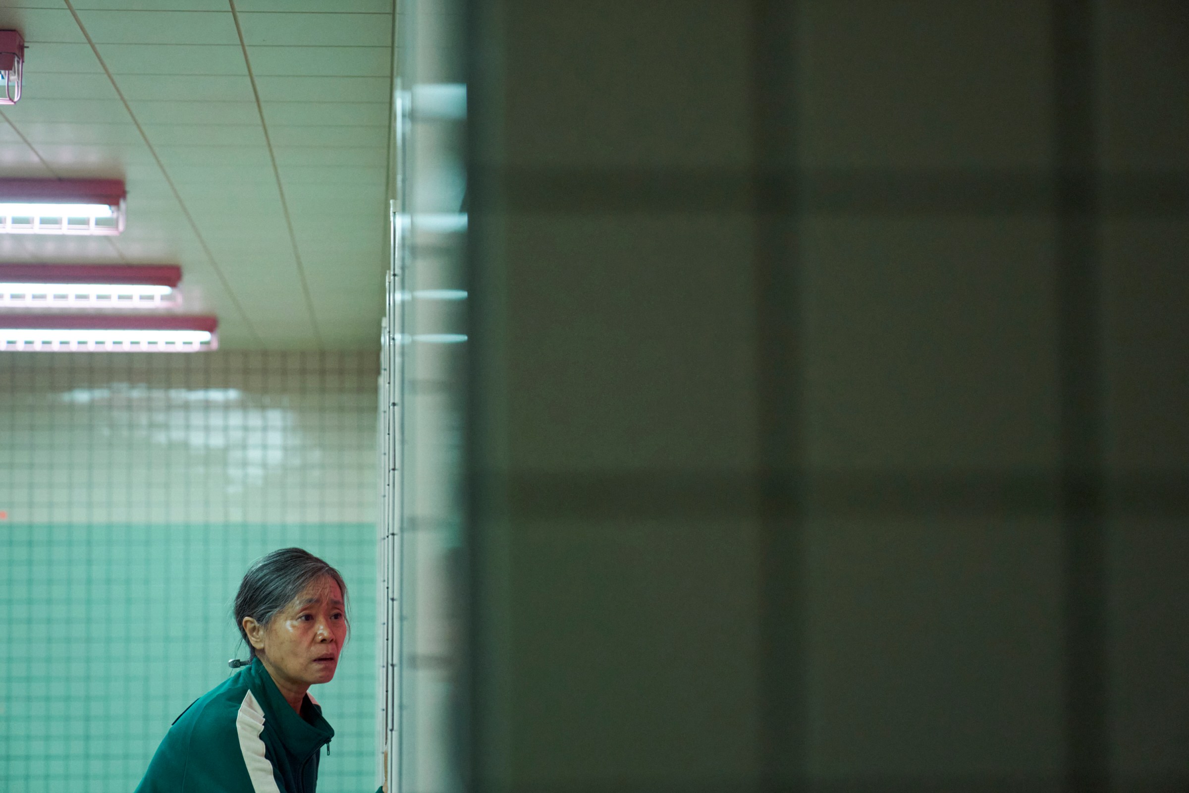 Geum-ja (Kang Ae-sim) looking concerned in a bathroom in a still from Squid Game season 2