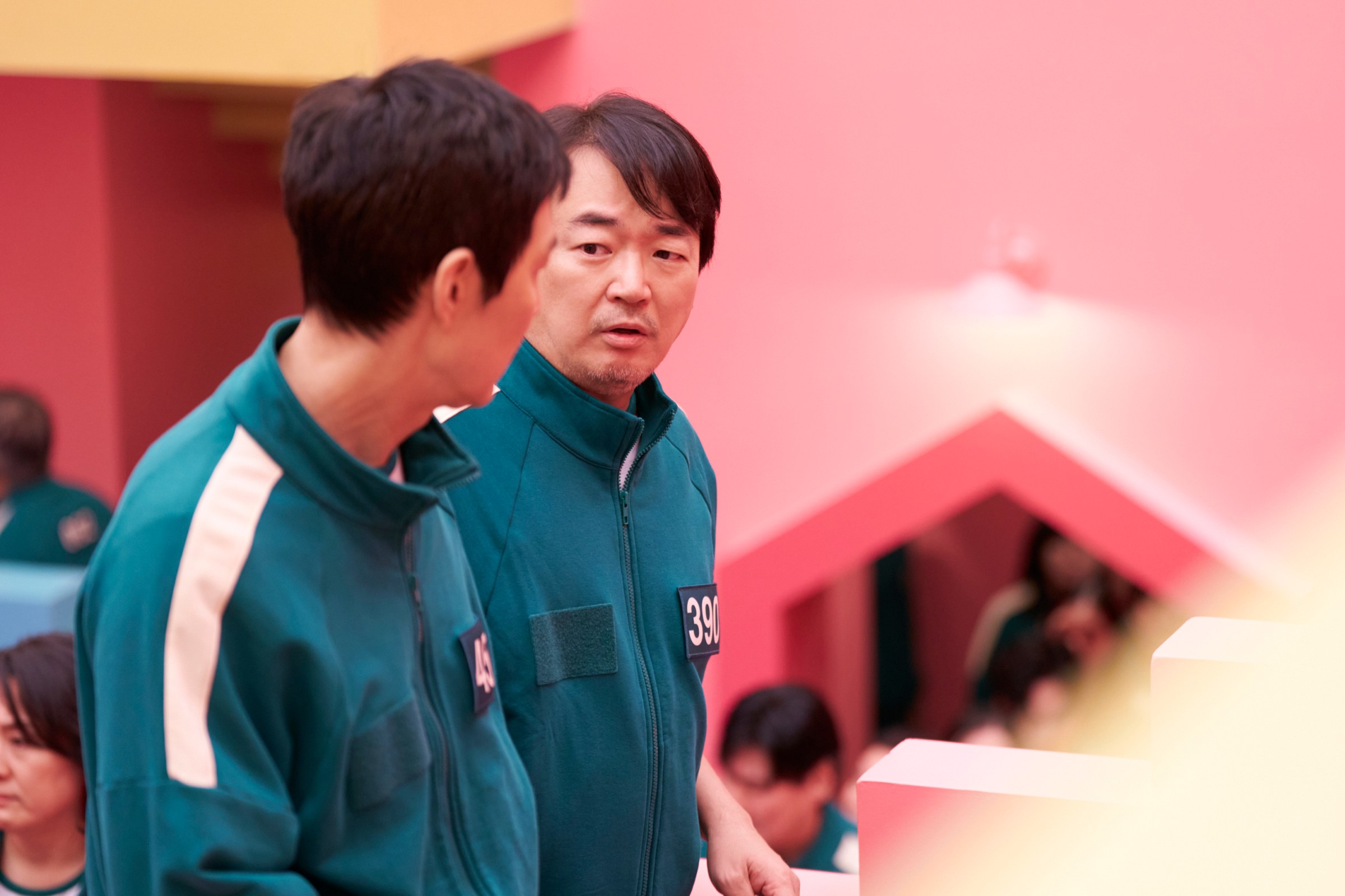 Jung-bae (Lee Seo-hwan) talking to Gi-hun in a still from Squid Game season 2