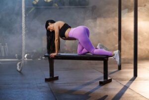 A woman stretching on a workout bench