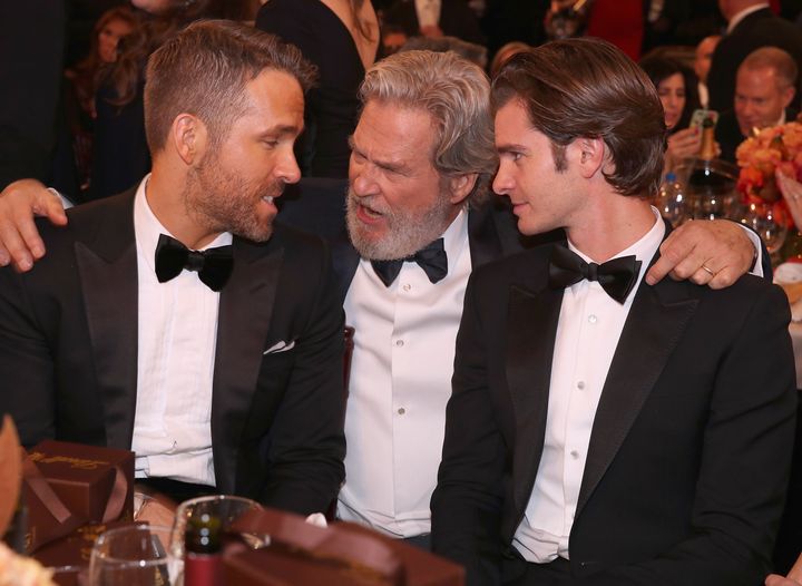 Ryan Reynolds, left, and Andrew Garfield, right, chat with fellow actor Jeff Bridges at the Golden Globes in 2017.