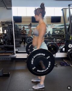 Hannah Bower is seen using a barbell during a workout.