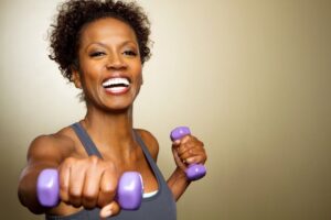 Happy older woman working out with dumbbells