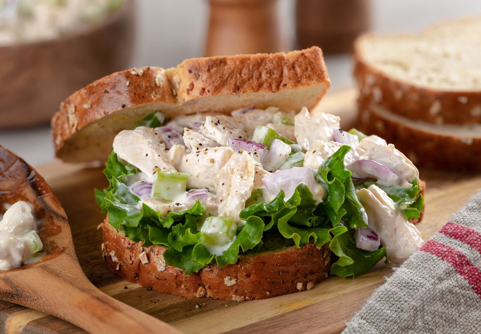 Chicken salad sandwich on wooden table.