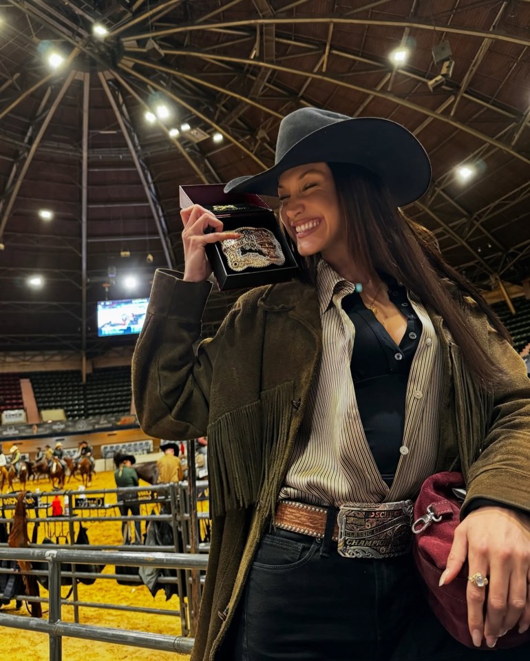 Dressed in a black cowboy hat and green tasselled jacket, Bella Hadid beams with pride as she holds up her medal