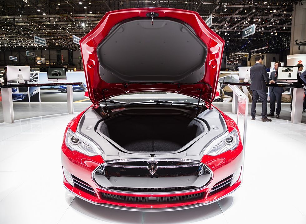 A Tesla in showroom with the front trunk/hood open